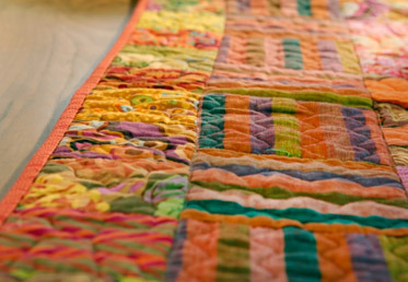 Liza Lucy deconstructs quilt construction and its vernacular – explaining patches, blocks, batting, sashing, binding, borders, quilting and more. 
