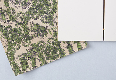 Jody Alexander explains which fabrics work best, and shows the traditional Japanese technique of backing fabric with washi paper to create a durable book cloth that can be used to create hardcover books and personalize your book projects. 