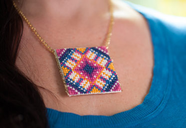 Anna Maria makes cross-stitch modern with this pendant, worked up in one of her signature bright palettes. The small scale makes this project terrific for new cross stitchers.