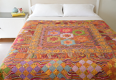 Kaffe Fassett and Liza work together to create a masterful medallion quilt in rich, warm tones. The quilt begins with a stunning medallion center that is comprised of English paper-pieced hexagon rings and hand-appliqued fussy-cut fabrics. 