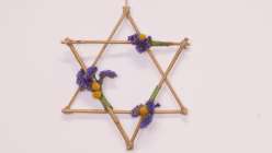 Two bamboo stars intersecting to make a Star of David with three small nosegays of dried flowers, from Cobi's Botanical Boughs for All Seasons Creativebug class