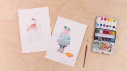 Two watercolor paintings, one of a snowman and one of a sledder, both from Maria Carluccio's Celebrate the Season Daily Holiday Painting Practice class on Creativebug.