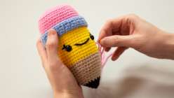 A pair of hands holding a crocheted pencil stuffy from Vincent Green-Hite's Crochet an Amigurumi Pencil Creativebug class