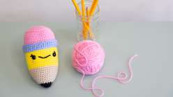  A stuffed crocheted pencil from Vincent Green-Hite's Crochet an Amigurumi Pencil Creativebug class and a ball of pink yarn
