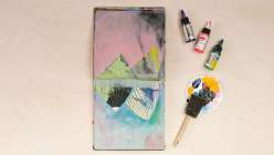 A vertically-oriented sketchbook spread from Abby Houston's Abstract Art Making Daily Practice class on Creativebug plus three bottles of high-flow acrylic paint and a sponge paint brush