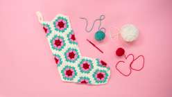A four-color granny hexagon crocheted Christmas stocking from Twinkie Chan's Crochet an Heirloom Granny Hexagon Stocking class on Creativebug