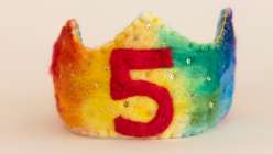 A felted rainbow birthday crown with the number five in red felt, made by Melissa of Hex House Crowns in her Wool Felting: Make an Heirloom Celebration Crown class on Creativebug