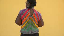 Tian Conaughton wearing a rainbow-colored crochet vest made in her Creativebug class, Crochet the Reignbow Vest
