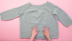 A sea-green crocheted sweater made in Twinkie Chan's Design and Crochet a Top-Down Bobble Sweater class on Creativebug.