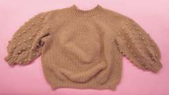 A tan monochrome crocheted sweater with tonal bobbles and puff sleeves made in Twinkie Chan's Design and Crochet a Top-Down Bobble Sweater class on Creativebug.