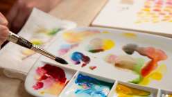 A watercolor paint palette filled with swatches from David Tenorio's Essential Color Mixing class on Creativebug