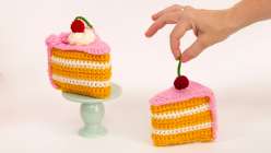 Two crocheted cake slices topped with yarn whipped cream and a cherry from Twinkie Chan's Crochet Cakery Daily Practice class on Creativebug