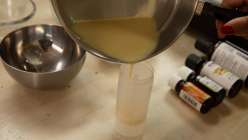 Liquified deodorant being poured into a cylindrical plastic container in Arina Soler of BellaCreme's Make a Natural Deodorant class on Creativebug