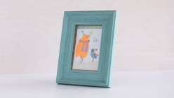 A framed gift tag featuring two birds, made using cut decorative paper by Dawn M. Cardona in her Make a Collage Art Tag class on Creativebug.