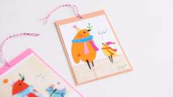 A gift tag image of two birds, made using cut decorative paper by Dawn M. Cardona in her Make a Collage Art Tag class on Creativebug.