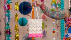 A white and pink crocheted lantern made by Twinkie Chan in her Crochet Home Decor: Make Hanging Lanterns class on Creativebug.