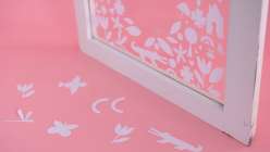 A glass window decorated with floral shapes of paper made by Dawn M. Cardona in her Cut-Paper Silhouttes for Home Decor class on Creativebug.