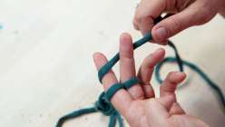A pair of hands demonstrating a two-stitch finger knitting technique in Faith Hale's Finger Knitting class on Creativebug.