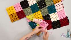Twinkie Chan seaming together a crochet sweater she made in her Crochet a Granny Square Cardigan class on Creativebug. 