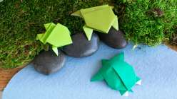 A folded paper origami turtle and two origami frogs made in Faith Hale's Origami Safari Daily Practice class on Creativebug