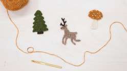 A crocheted reindeer, a crocheted tree, and a crocheted mushroom made by Twinkie Chan in her Holiday Crochet Applique class on Creativebug