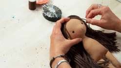 A still of hair being sewn on to a doll in Katia Ferris's Sew a 14-Inch Rag Doll class on Creativebug.