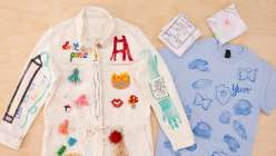 A colorful white jumpsuit and a light blue tshirt embellished with hand-carved stamps, embroidery, painting, and drawings by Risa Iwisaki Culbertson in her class Wearable Wins on Creativebug