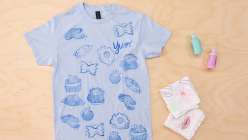A light blue t-shirt embellished with hand-carved stamps by Risa Iwisaki Culbertson in her class Wearable Wins on Creativebug