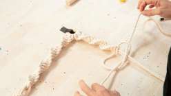 A pair of hands tying a macrame knot in Cobrina's Home Decor: Three Macrame Rope Projects class on Creativebug.