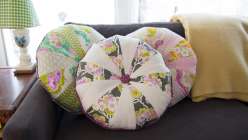 Heather Bailey teaches you how to make a fun patchwork throw pillow using fabrics from her True Colors collection with FreeSpirit. Heather teaches the front and back of this round, tufted pillow and how to make your own piping and fabric-covered buttons.